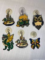 Group of six stained glass suncatchers showing duck, train, owl, dragon, second duck, butterfly