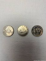 Three Canadian Voyageur dollars front view, years visible