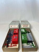 Both HO scale box car kits in open boxes with contents visible