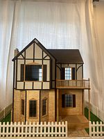 Front view showing Tudor styling, windows, fence and base