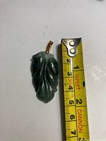 Pendant beside tape measure showing length about 2 inches