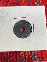 Obverse side of holed coin in 2×2 holder