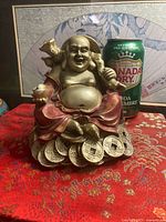 Front view of Laughing Buddha figurine with soda can for scale