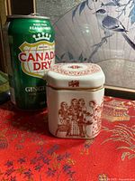 Front view of jar beside soda can for scale
