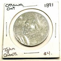 Obverse of token showing bust of John Abbott in cardboard 2×2 holder