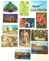 Selection of postcards laid out showing variety of subjects such as aircraft, flowers, buildings