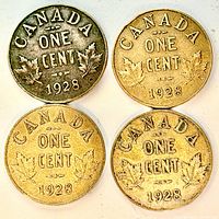 Four 1928 Canadian one-cent coins reverse side showing maple leaves and date