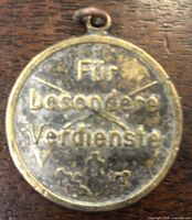 Obverse of medal showing inscription, crossed rifles, oak leaves, eyelet