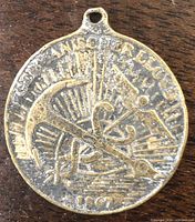 Front view of medal displaying anchor and caduceus design with legend and date