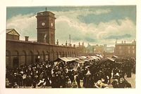 Front of postcard showing market scene and title