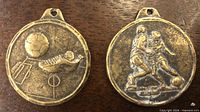 Fronts of both soccer medals showing designs
