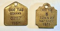 Both brass dog tags side by side showing shapes, text, holes