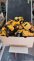 Box filled with assorted yellow CAT construction toys