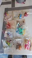Ten sealed McDonalds Happy Meal toy packets arranged on table