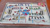 Full view of tabletop hockey game with all players, nets and pucks visible
