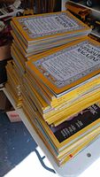 Multiple high stacks of yellow-border National Geographic magazines on a table
