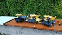 Group of five Tonka construction vehicles lined on tabletop