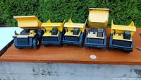 Front view of five Tonka dump trucks