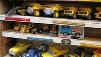 Shelves showing multiple yellow dump trucks and assorted vehicles