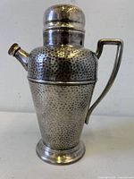 Front view showing hammered surface, spout, lid and base