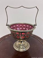 Front view of silver-plated bonbon basket with handle up