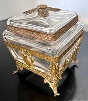 Three-quarter view showing glass body, ormolu mounts, feet