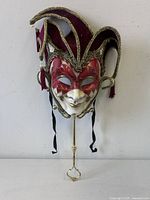 Front view of Venetian jester mask, rod attached