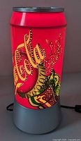 Front view of Coca-Cola can-shaped rotating lamp powered on