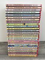 Spine view of full stack showing around thirty numbered Baby-sitters Club titles