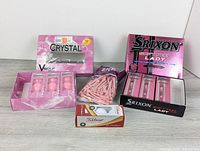 All items in lot: three golf ball packages and bag of tees