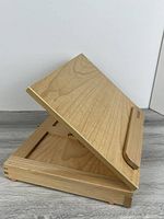 Easel open at angled position showing support arm and wood grain