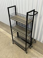 Angled view of entire cart showing three shelves, handle and casters