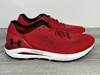Side profile of both shoes showing red mesh uppers, HOVR midsoles, black logo