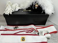 Full lot showing chapeau, gloves, two sashes, hat box