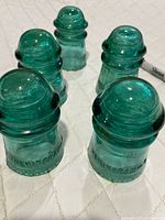 Group of five aqua Hemingray glass insulators