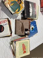 Stacks of approximately 200 7-inch singles in paper and picture sleeves on table