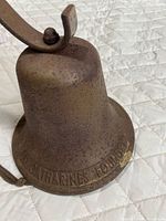 Side view of cast iron bell displaying St Catharine's Foundry inscription and rusted surface