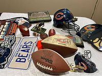 Overview of entire lot showing helmet, footballs, signs, figurine, desk clock, framed photo, watches and accessories