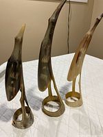 Full view of the three horn bird figurines standing together
