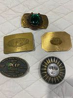 Group shot of all five belt buckles