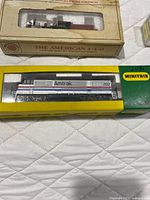 Minitrix Amtrak diesel locomotive and American 4-4-0 steam locomotive boxes side by side