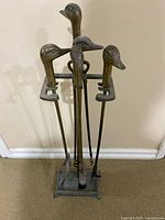 Full view of tool set on stand showing duck-head handles and four tools