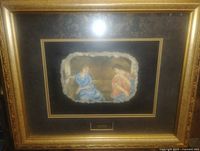 Full view of framed artwork showing gold frame, mat, and painted stone
