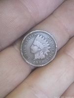 Obverse view of 1906 Indian Head cent held between fingers