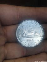 Reverse side of 1983 Canada dollar showing voyageur canoe design and date