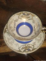 Top view of teacup nested in saucer showing blue band and gold overlay