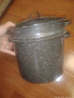 pot with lid and strainer held in hand
