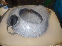 Top view of speckled blue-grey enamel bedpan showing overall form, spout and bowl