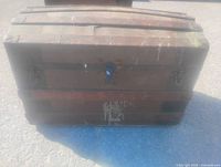 Front view of arched top wooden steamer trunk showing lock and hardware