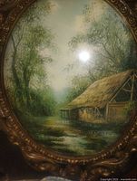 Close-up of landscape print under convex glass inside ornate metal frame